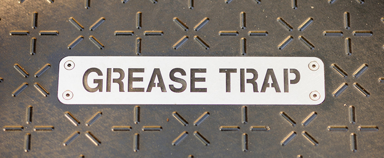 'GREASE TRAP' sign on drain cover 